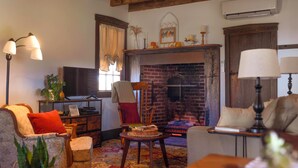 Una sala de estar acogedora con chimenea, televisor y asientos cómodos.