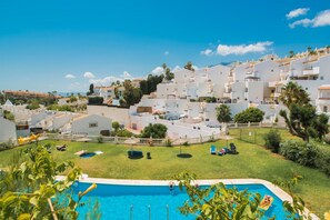 A residential area with white buildings, a swimming pool, and a clear blue sky. - Spectacular House. Ocean Vistas (Benalmádena)