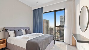 A modern hotel room with a large bed, a nightstand, a mirror, and a view of the city through a large window. - Silkhaus Executive Residences, Dubai Hills (Dubai)