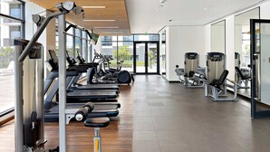 A modern gym with treadmills, weight machines, and a large mirror. - Silkhaus Executive Residences, Dubai Hills (Dubai)