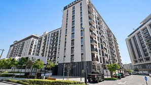 A multi-story building with the name 'EMAAR' on the facade, surrounded by greenery and a clear sky. - Silkhaus Executive Residences, Dubai Hills (Dubai)