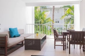 Un balcone con divano, sedie e tavolo.