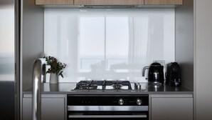 Una cocina moderna con estufa a gas, cafetera y una planta pequeña.