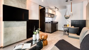 Una sala de estar moderna con un sofá, una mesa de centro y un televisor de pantalla plana montado en la pared.