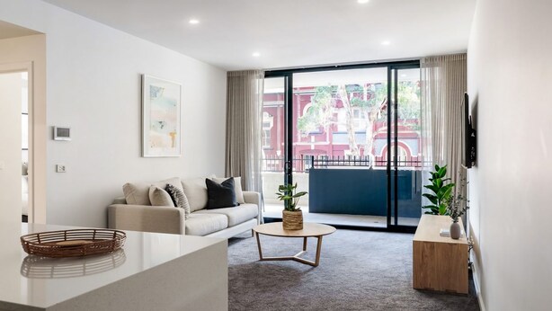 Una sala de estar moderna con un sofá, una mesa de centro y un televisor.