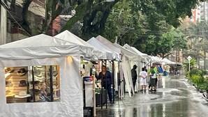 A row of white tents along a wet street with people walking. - Exclusivo Apartamento Privado Zona Rosa Sabaneta (Sabaneta)