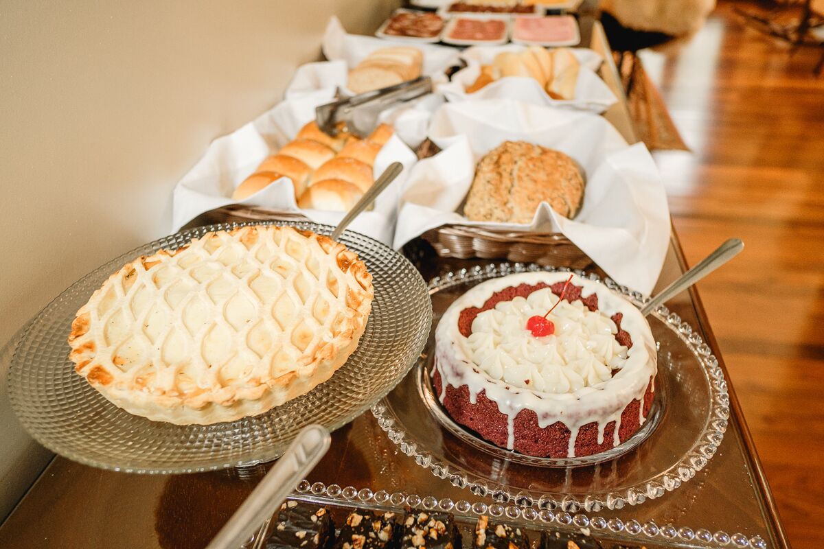 Una mesa de buffet con diversos pasteles y postres.