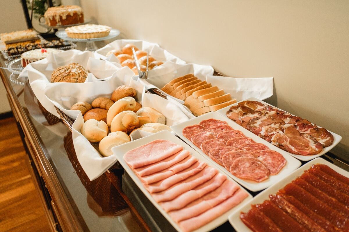 A buffet with various food items including pastries, meats, and desserts.