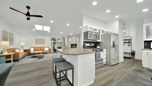 A modern open-plan living area with a kitchen, a dining area, and a bar. - Huge CDA Getaway With Foosball And BBQ (Coeur d'Alene)