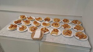 A kitchen counter with plates of pastries and a basket of bread. - Hotel BA Congreso (Buenos Aires)