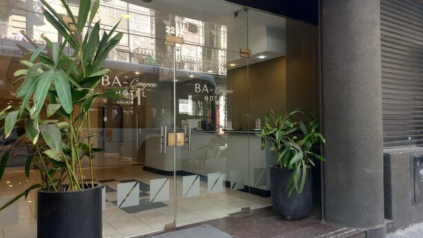 A hotel entrance with glass doors, potted plants, and a visible reception area. - Hotel BA Congreso (Buenos Aires)