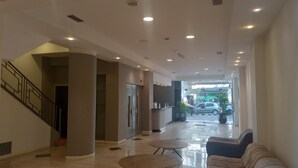 A spacious lobby with a staircase, a reception desk, and a seating area. - Hotel BA Congreso (Buenos Aires)