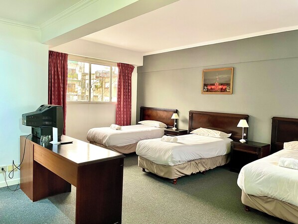 A hotel room with two single beds, a desk with a television, and a window with curtains. - Hotel BA Congreso (Buenos Aires)