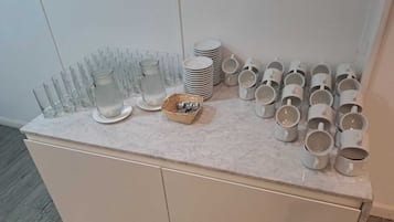 Una encimera de cocina con diferentes vasos y tazas.