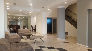 A spacious lobby with a checkered floor, a sofa, a coffee table, and a staircase. - Hotel BA Congreso (Buenos Aires)