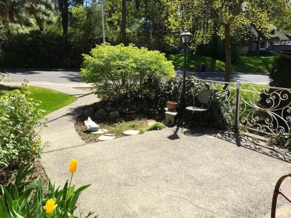 Relax in a serene outdoor space surrounded by lush greenery and a decorative fence.