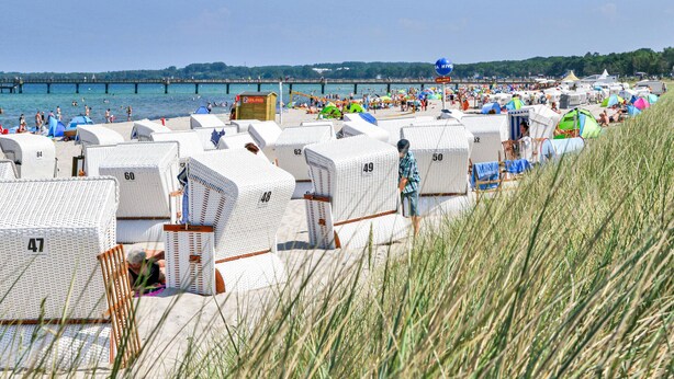 A beachside area with rows of numbered beach huts, a pier in the background, and a clear view of the sea. - Beautiful home in Jesendorf with WiFi (Jesendorf)