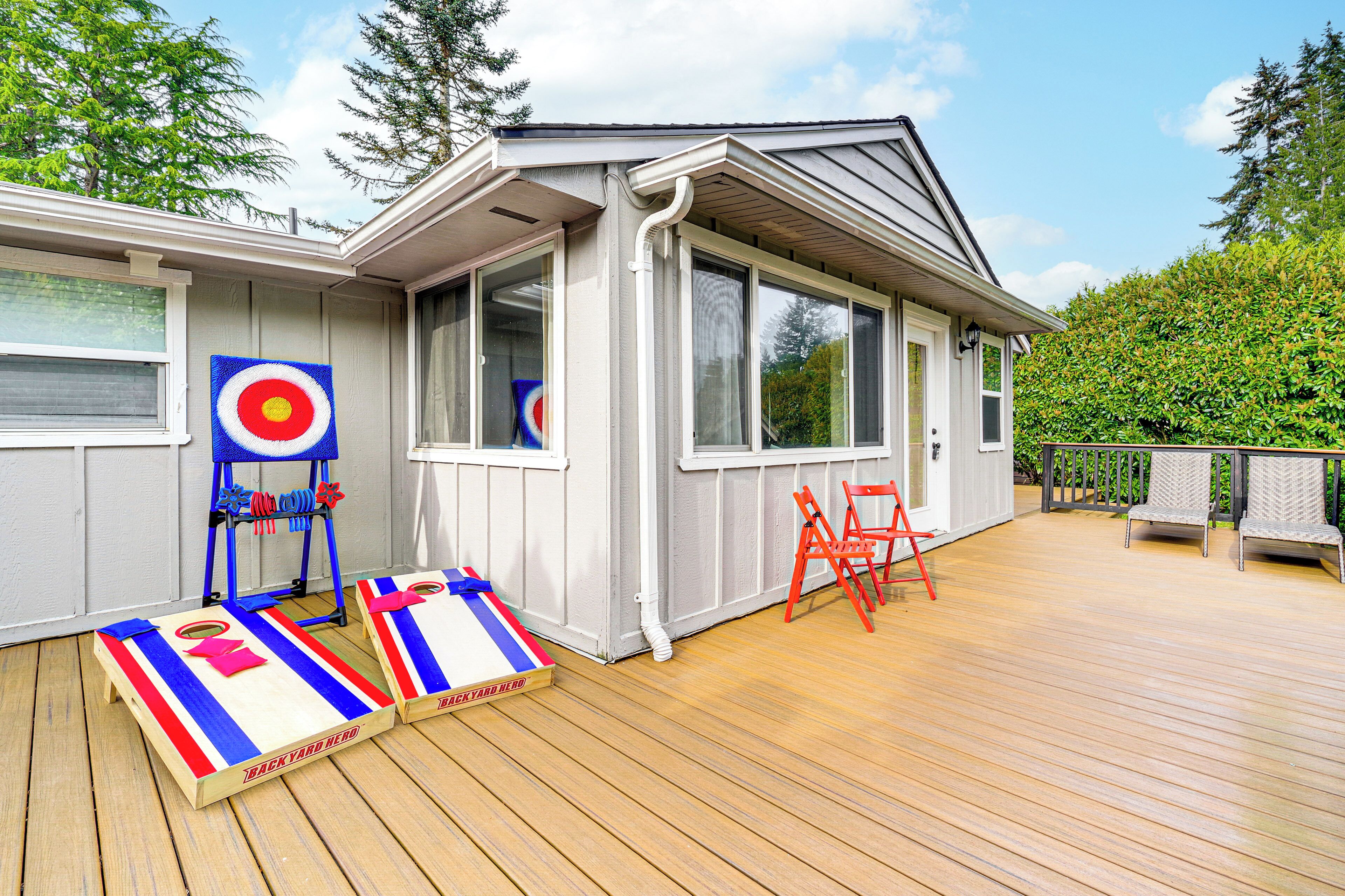 A deck with a target game, a small table, and two chairs.
