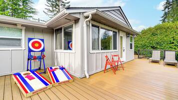 A deck with a target game, a small table, and two chairs.