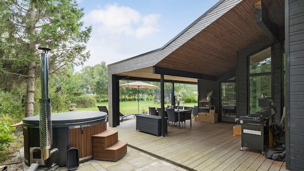 A covered outdoor patio with a hot tub, seating area, and barbecue grill. - 4 bedroom gorgeous home in Glesborg (Glesborg)