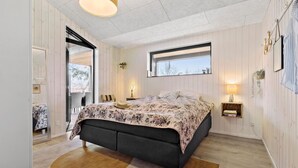 A bedroom with a bed, a window, a bedside table, and a mirror. - 4 bedroom gorgeous home in Glesborg (Glesborg)