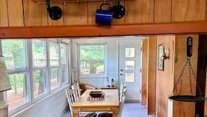 Una cocina con armarios de madera, una mesa de comedor y una ventana con vistas a un jardín.