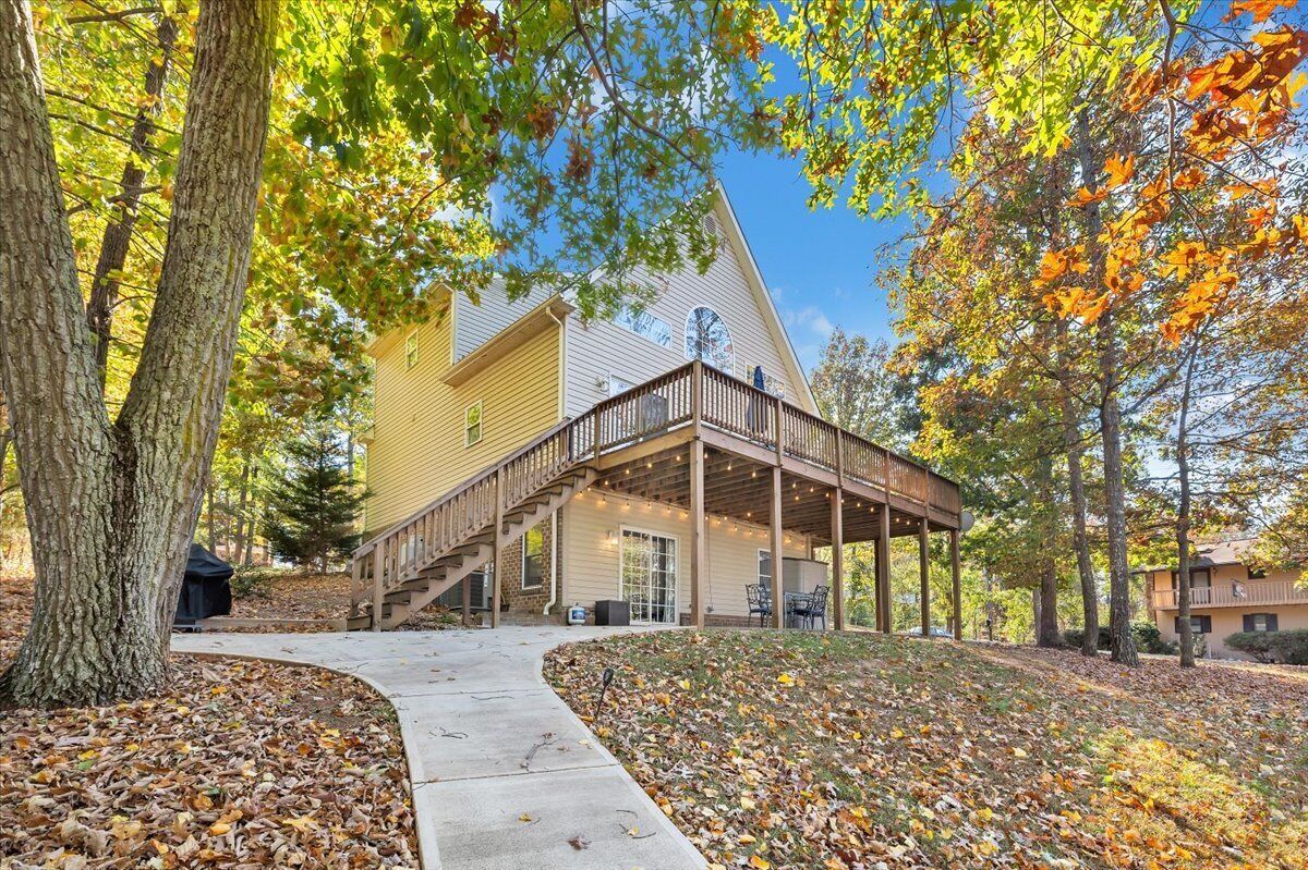 A two-story building with a covered outdoor deck and a staircase leading to the entrance.