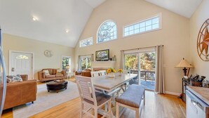 A spacious living room with a dining area, large windows, and a kitchen. - Shangri-La -dogs friendly, firepit, wifi, 2 kayaks, 2 kitchens, and a Pool Table (Huddleston)