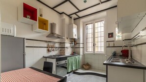 A compact kitchen with a stove, sink, and a window.