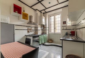 A compact kitchen with a stove, sink, and a window.