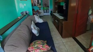 A living room with a sofa, a TV, and a wooden cabinet. - Espaço do Jonga Itacaré-ba (Itacaré)