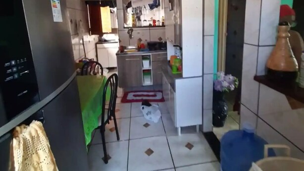 A compact kitchen with a refrigerator, sink, and a dining area with a chair and table. - Espaço do Jonga Itacaré-ba (Itacaré)