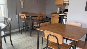 A dining area with a wooden table and chairs, a ceiling fan, and a kitchen in the background. - Cute & Friendly 1-BR 10 Mins From Nash (Nashville)