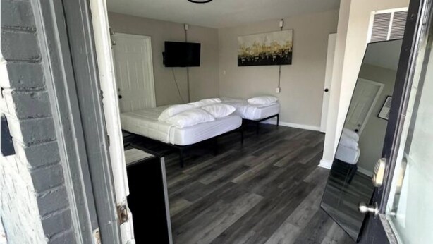A room with a bed, a TV, and a painting on the wall. - Cute & Friendly 1-BR 10 Mins From Nash (Nashville)