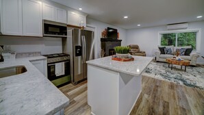 A modern kitchen with white cabinets, stainless steel appliances, and a marble countertop. - Bellingham Waterfront Retreat, Private Dock, Amazing Views (Bellingham)