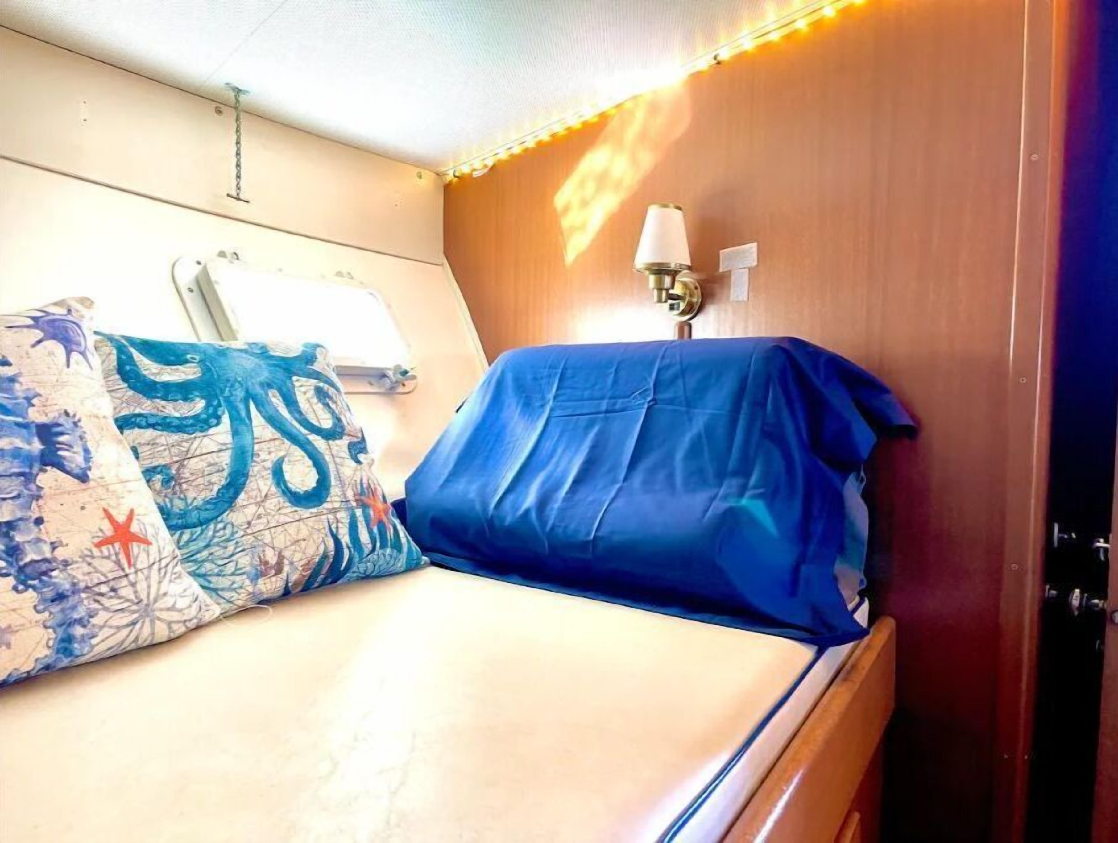 Une petite chambre confortable, avec un lit, une table de chevet et une lampe.