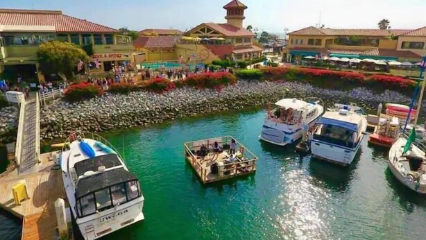 Un puerto deportivo con barcos amarrados, un puente y edificios con tejados rojos.