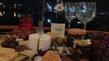 A charcuterie board with cheese, grapes, and crackers on a wooden table.