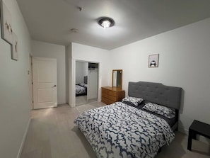 Ein Schlafzimmer mit Bett, Schminktisch, Spiegel und Kleiderschrank.
