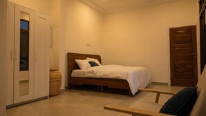 A bedroom with a bed, a wardrobe, and a bench. - Lokko Serene One Bedroom (Accra)