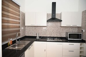 Geladeira, micro-ondas, cooktop, talheres/pratos/utensílios de cozinha