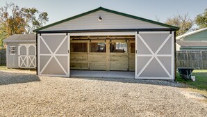 A single-story building with a sloped roof and a large open garage door. - ‘Beach Bay Pony Place’ w/ Ponies: 1 Mi to Water! (Chincoteague)