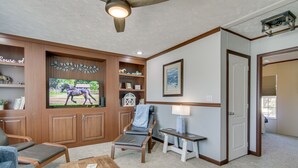 A living room with a television, a chair, a coffee table, and a bookshelf. - ‘Beach Bay Pony Place’ w/ Ponies: 1 Mi to Water! (Chincoteague)