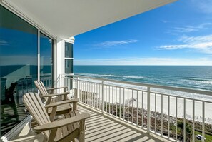 A balcony with wooden chairs, a white railing, and a view of the ocean. - Palacio 806 | Oceanfront | Resort Amenities | My Beach Getaways (Pensacola)