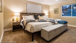 A bedroom with a bed, nightstands, a ceiling fan, a window, and a painting. - Ultimate Relaxation Retreat w/ Game Room & Hot Tub (Ahwahnee)
