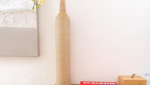 Un bureau en bois sur lequel se trouve un vase de fleurs d’orchidées blanches, un livre rouge intitulé « ST. BARTHUS » et une boîte en bois.