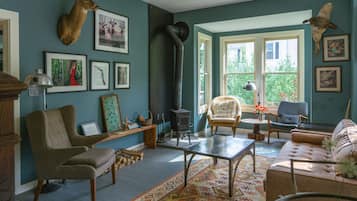Uma sala de estar aconchegante com lareira, assentos confortáveis e diversas fotos emolduradas nas paredes.