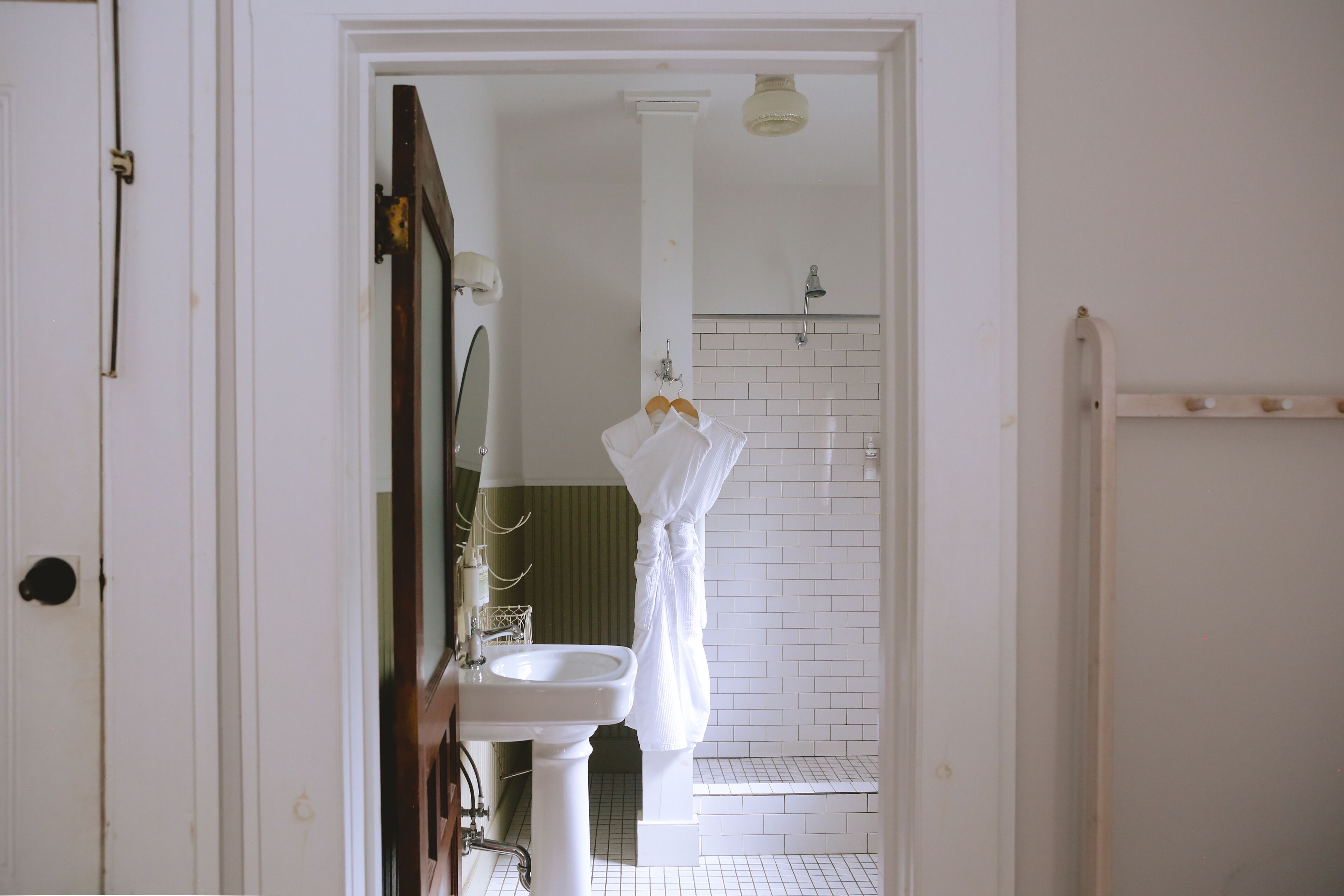 A bathroom with a white sink, a mirror, and a shower area.