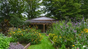 A garden with a gazebo, various flowering plants, and a pathway. - The North Branch Inn (North Branch)