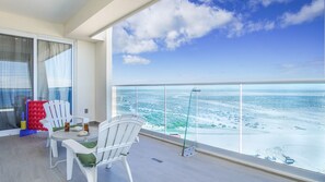 Ein Balkon mit Tisch und Stühlen, eine Glasdusche und Blick auf eine verschneite Landschaft.